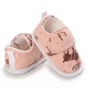 Détail de chaussures de marche bébé roses à semelle souple et motifs de dessin animé