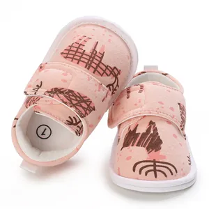 Détail des chaussures de marche roses pour bébé avec motif chien, semelle souple et velcro
