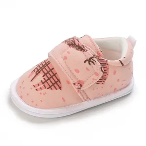 Gros plan d'une chaussure pour bébé rose avec motif hérisson et sangle velcro solide