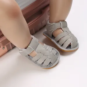 Détail de sandales grises pour bébé avec brides tressées et fermeture velcro