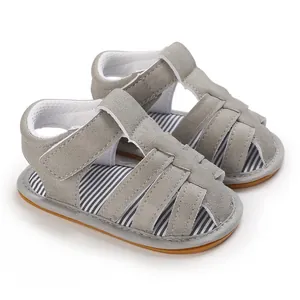 Primer plano de sandalias grises para bebé niño con plantilla a rayas y suela de goma suave