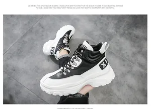 Vista laterale di sneakers chunky da uomo alte in bianco e nero con fibbie in metallo.