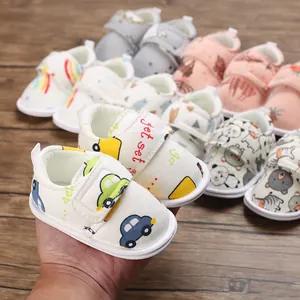 Gros plan sur des chaussures de marche pour bébé avec motifs d'animaux et voitures