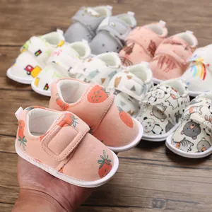 Gros plan de chaussures bébé rose à motif fraise avec velcro et semelles souples