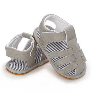 Detalle de sandalias grises para bebé con forro a rayas y suelas de goma suave y flexible