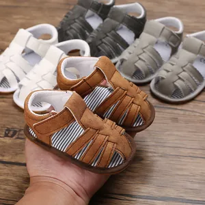 Détail de sandales d'été souples pour bébé en plusieurs couleurs sur fond de bois