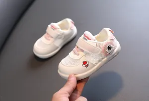 Detalle de zapatos para caminar para bebé en malla transpirable con diseño astronauta.
