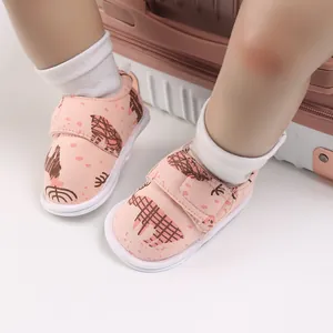 Détail de chaussures de marche roses pour bébé avec motif de cerf et bande velcro.