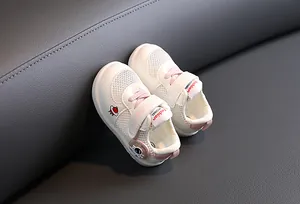 Detalle de zapatos de marcha para bebé en malla transpirable con parche de astronauta