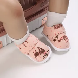 Vue détaillée de chaussures bébé roses avec motifs d'animaux mignons et fermeture velcro