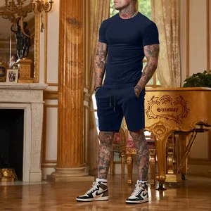 Model showcasing navy blue men's sports T-shirt and shorts set in an elegant room setting