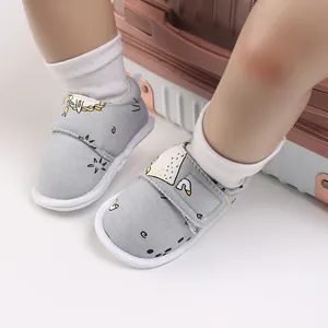 Gros plan de chaussures de bébé grises à motifs avec scratch et semelle souple