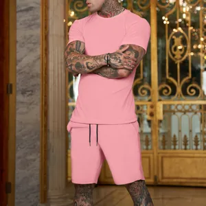 Detail view of a men's solid pink short-sleeved T-shirt and sports shorts set on a model