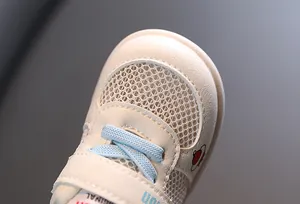 Detalle macro de zapatilla para niño con malla transpirable y cordones azul claro