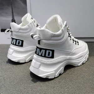 Vista dettagliata delle sneakers alte bianche con suola spessa e fibbia in metallo