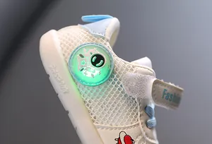 Detalle de zapatilla transpirable para bebé con astronauta luminoso y cierre de velcro.