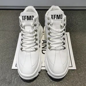 Dettaglio di sneaker alte bianche da uomo con suola spessa e occhielli in metallo.