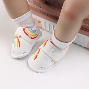 Gros plan de chaussures de marche pour bébé avec motif arc-en-ciel et velcro