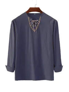 Detail shot of men's loose cotton shirt with lace-up collar and ethnic trim.