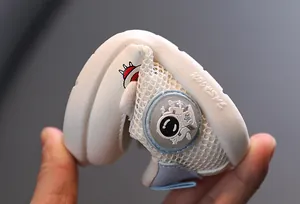 Primer plano de la suela blanda y flexible de zapatos blancos para bebés con astronauta