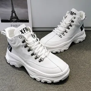Sneakers alte bianche da uomo con suole spesse e ganci in metallo in primo piano