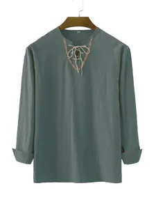 Detail of men's teal casual shirt with ethnic embroidery and drawstring V-neckline.