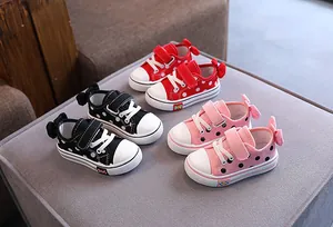 Collection of toddler girls' bow-accented polka dot canvas sneakers in red, black, and pink.