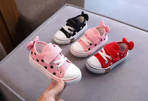 Toddler girls' canvas shoes with sweet polka dots and bow detail, soft-sole walker shoes.