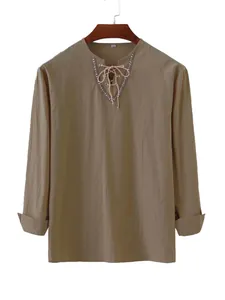 Close-up of khaki cotton shirt featuring decorative lace-up V-neck and intricate pattern trim.