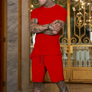 Fit detail of a man in a solid red crew neck sports t-shirt and drawstring shorts set