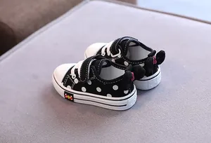 Black and white polka dot children's low-top canvas shoes with a cute bow detail on heel