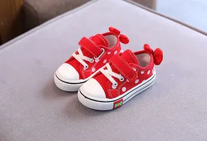 Detailed view of red polka dot toddler girl canvas shoes with a cute bow on the heel