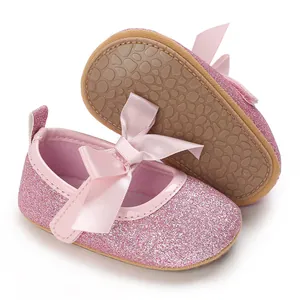 Close-up of pink glitter texture and anti-slip rubber sole on infant princess shoes with bow