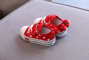 Red low-top polka dot canvas shoes for girls featuring cute bow decoration on the heel