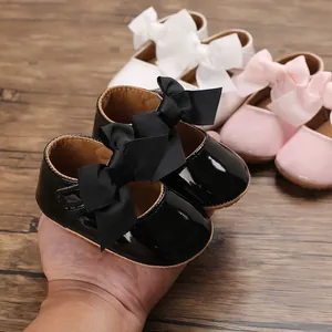 Nahaufnahme schwarzer PU-Babyschuhe mit großer Schleife für Mädchen im Prinzessin-Stil