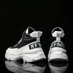 Sneakers alte da uomo in bianco e nero con suola platform spessa e ganci in metallo.
