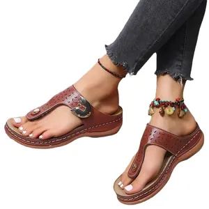 Womens brown wedge flip-flop sandals with laser-cut design and metallic buckle for beach wear