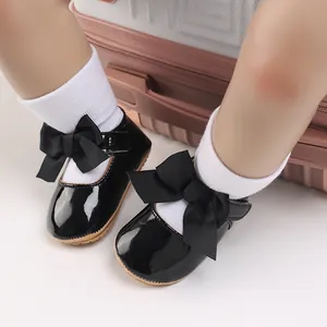 Detailansicht stilvoller schwarzer Lacklederschuhe für Babys mit großer Schleife