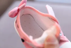 Close-up of the breathable mesh insole inside a pink polka dot baby canvas shoe with a bow