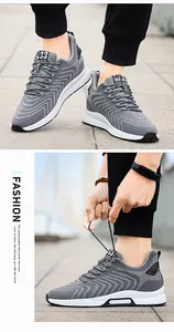 Close-up of grey breathable fly-woven sports shoes with hidden height increase feature.