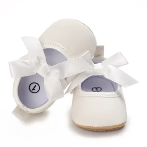 Close-up detail of white glitter baby princess shoes featuring elegant large satin bows