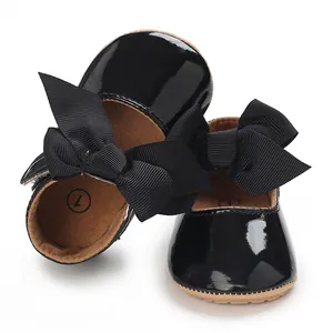 Detailansicht glänzender schwarzer Lacklederschuhe für Babys mit großen Schleifen