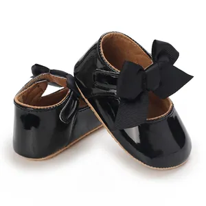Detaillierte Ansicht eleganter, glänzend schwarzer Baby-Prinzessin-Schuhe mit Schleifen