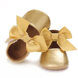 Detailansicht der goldenen Baby-Prinzessinenschuhe mit großen eleganten Schleifen am Spann