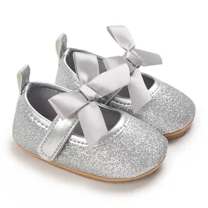 Detailed view of silver glitter baby Mary Jane shoes featuring a grey satin bow