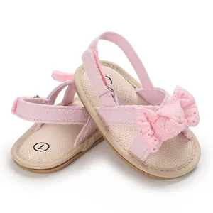 Macro detail showing the soft fabric insole and pink lace bow of baby girl walking sandals.
