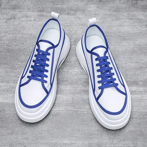 Vista dall'alto dettagliata di eleganti sneakers da uomo bianche e blu con suole morbide.