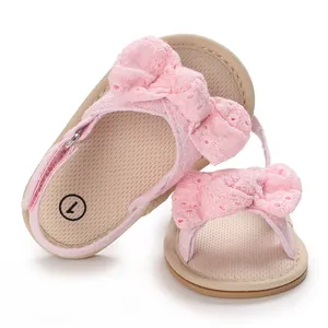 Detailed view of pink baby girl sandals featuring a lace bow and soft breathable sole