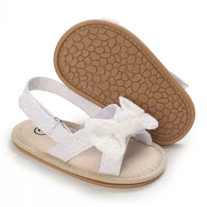 Detailed view of white baby girl walker sandals with lace bow and soft anti-slip sole