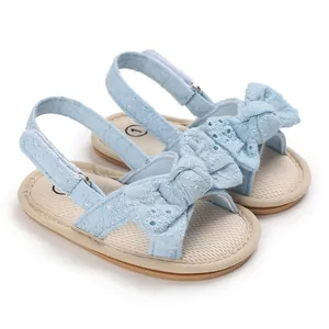 Close-up detail of light blue baby girl sandals featuring a soft sole and decorative bow design
